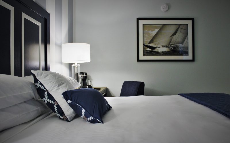 Bed closeup left King Room with Ship art on wall.